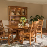 A dining room featuring a table surrounded by chairs and a china cabinet with dishes inside against wall behind the table, nicely arranged in a well-lit space